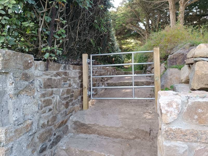 Réalisation d’un mur de soutènement maçonné à la chaux à Trébeurden et pose d’un portail sur poteau bois classe IV par Les Paysagistes du Trégor à Pleumeur-Bodou